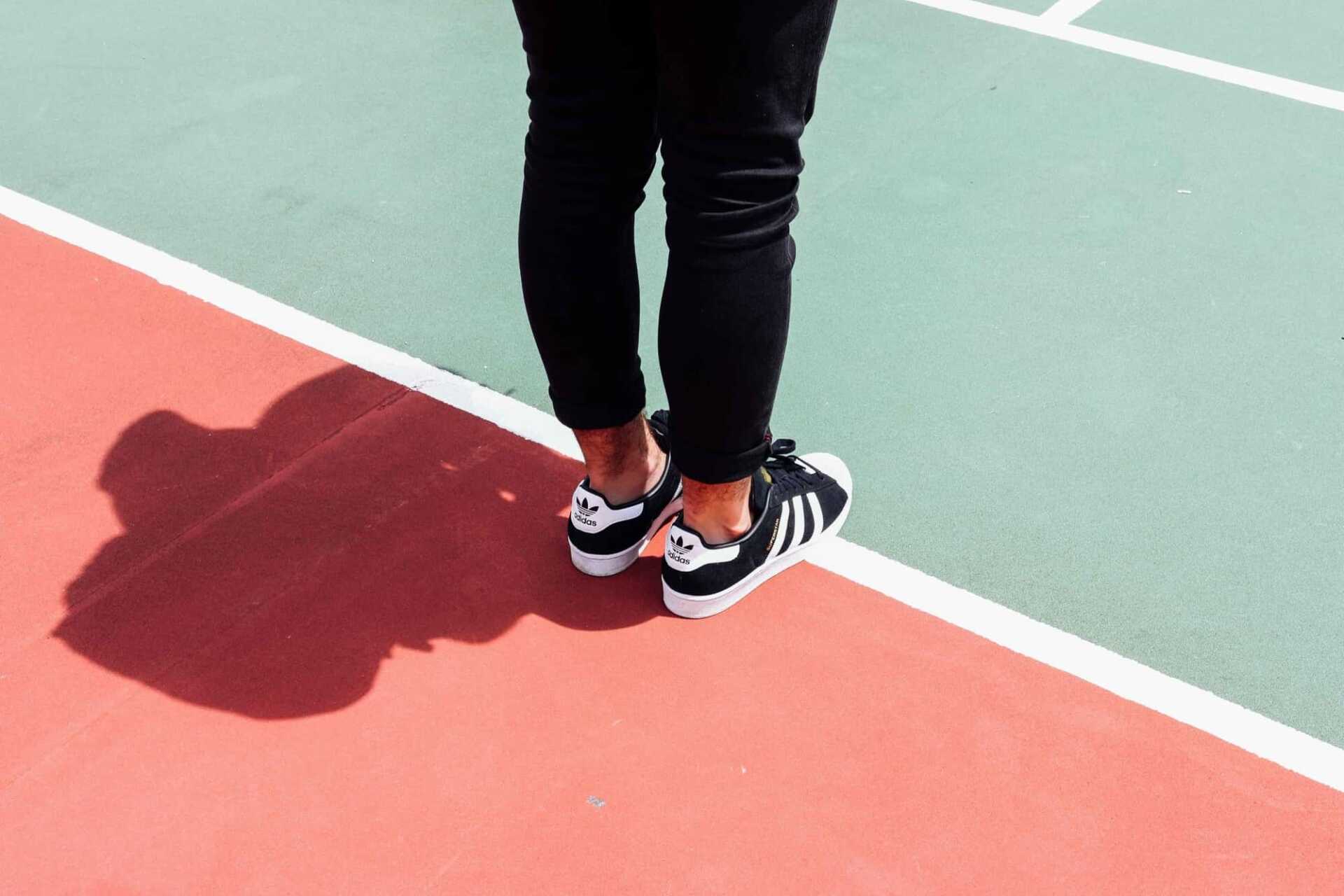 legs standing on a tennis court