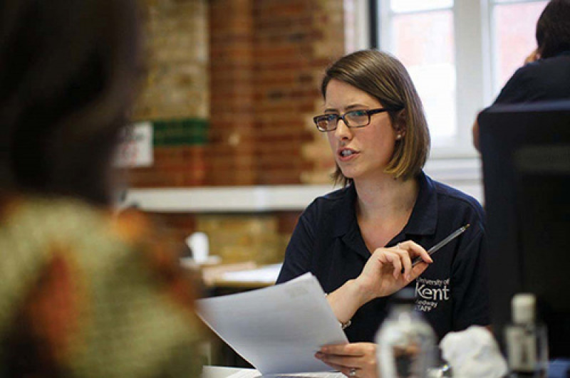 Person in University of Kent polo shirt talks to class of students