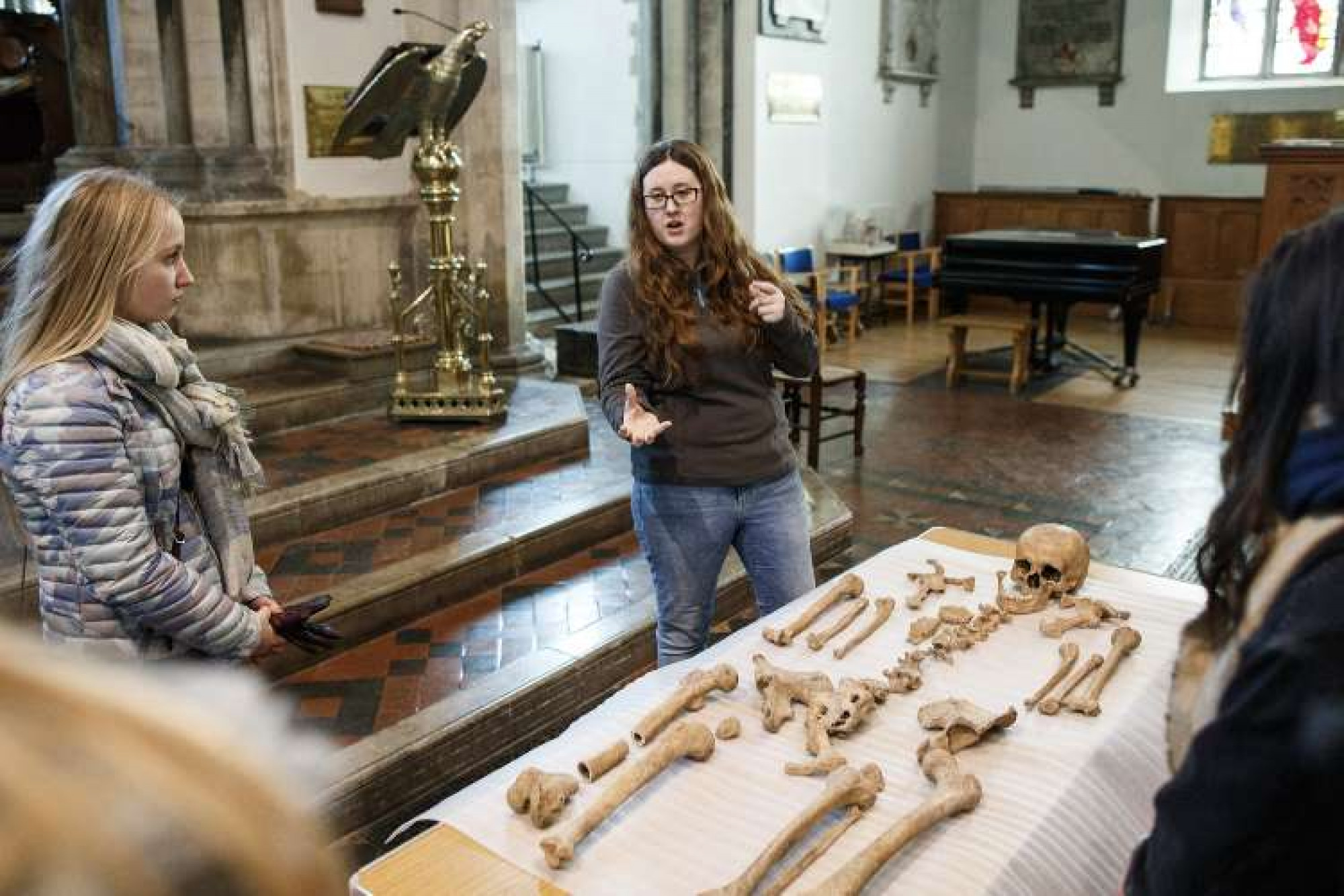 Expert showing ancient human skeleton to student group