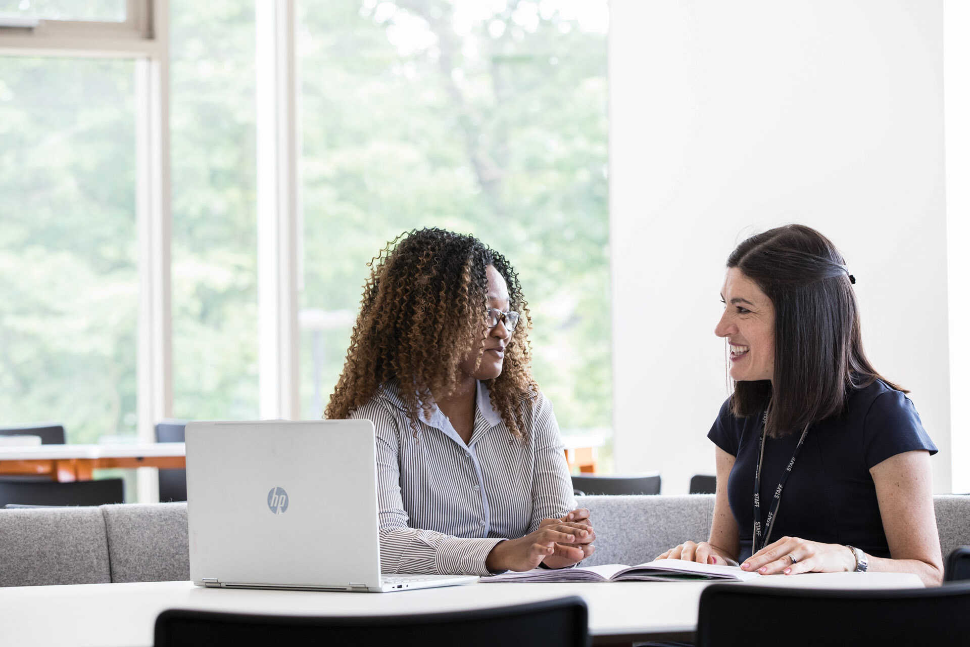 Female postgraduate academics sat talking at desk