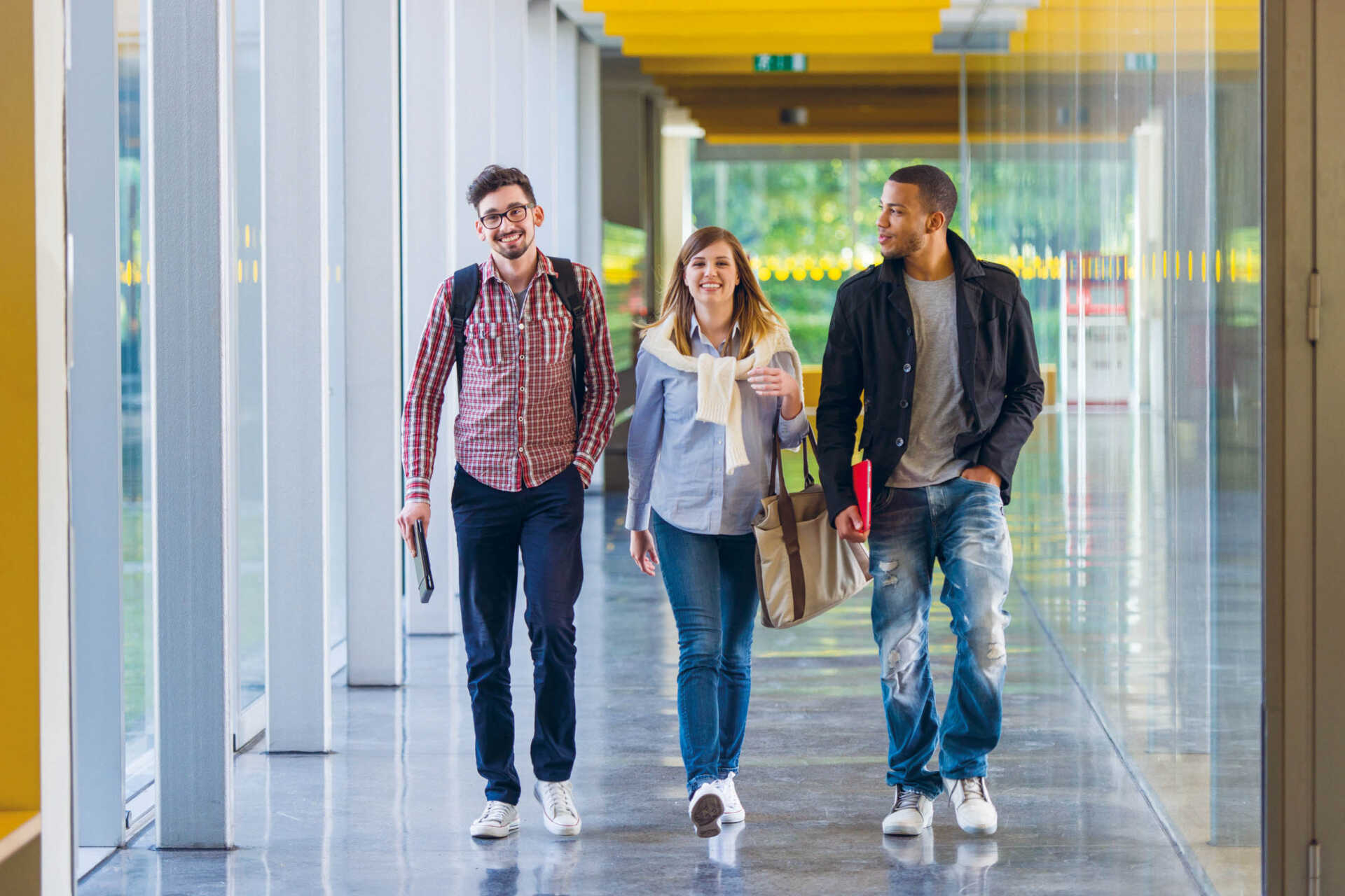 three students walking down corridor