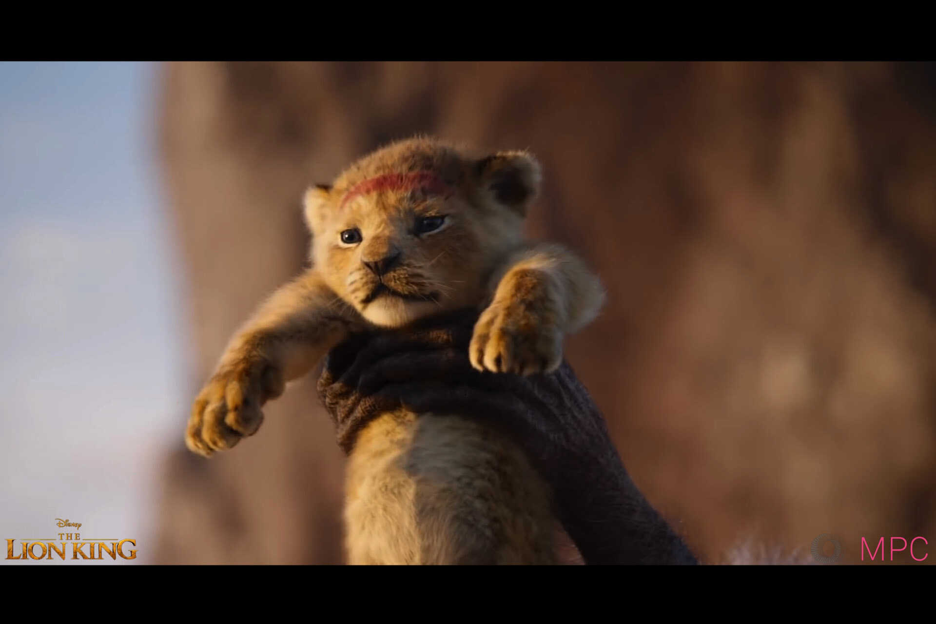 Scene from The Lion King where Simba is held aloft