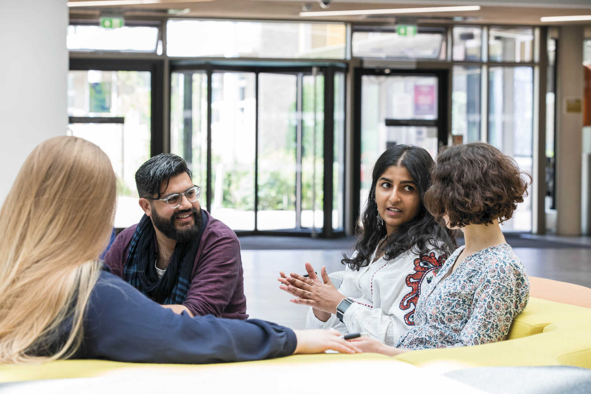 Four students sitting in a group talking