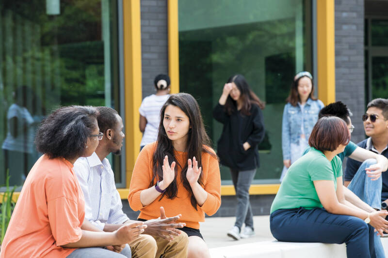 Students sat outside talking at the Canterbury campus.