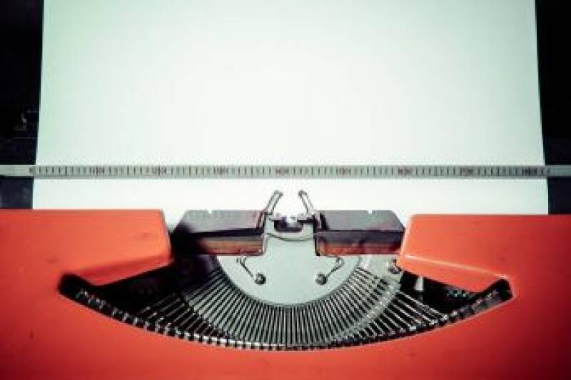 Red typewriter with blank white paper