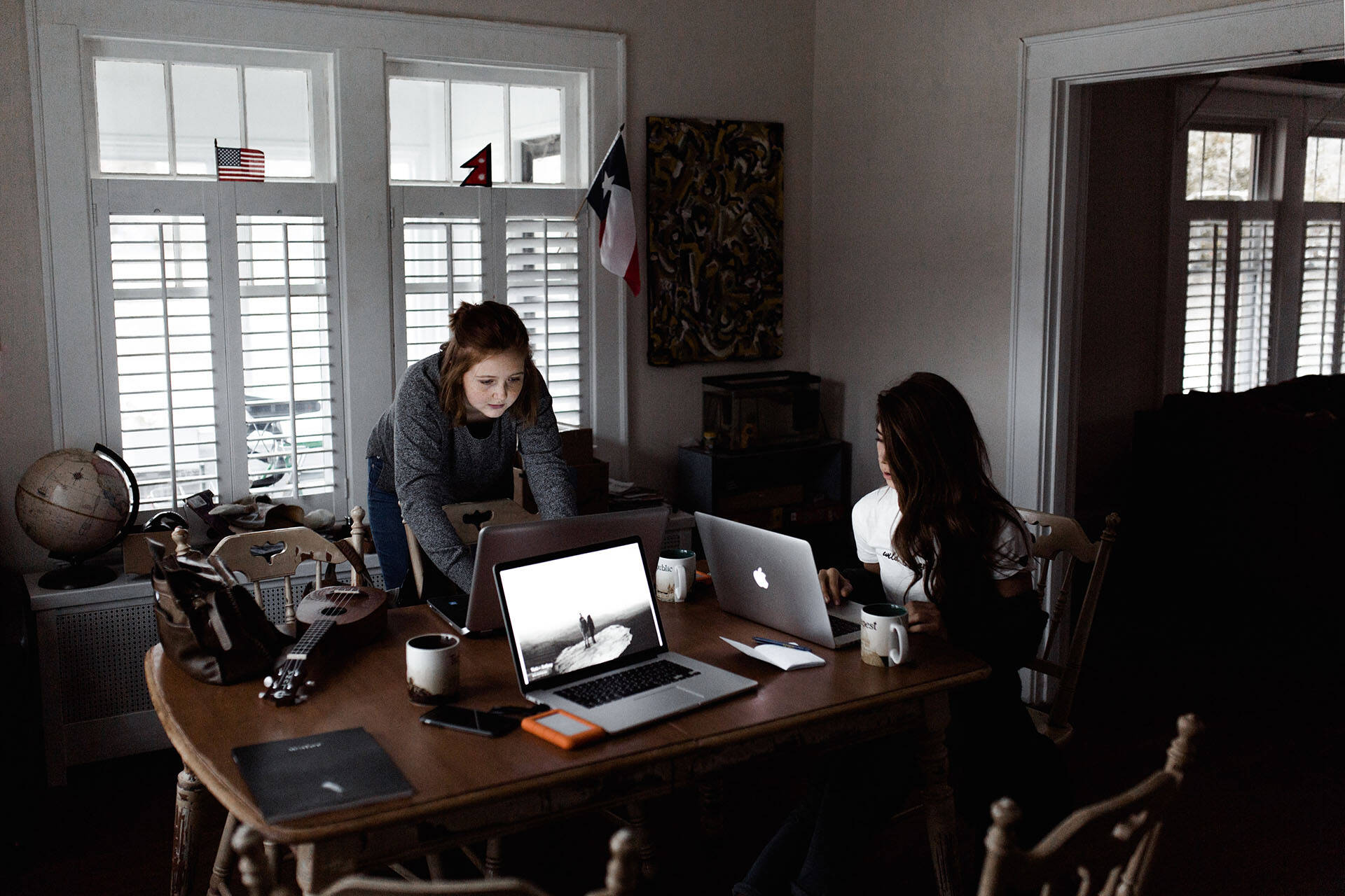Two female students using a dining room as a home office