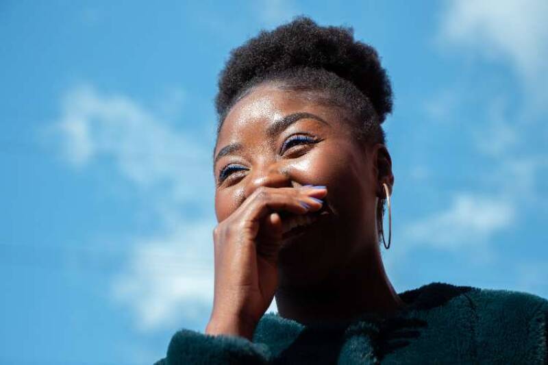 Young woman laughing with hand over her mouth Photo by Etty Fidele on Unsplash