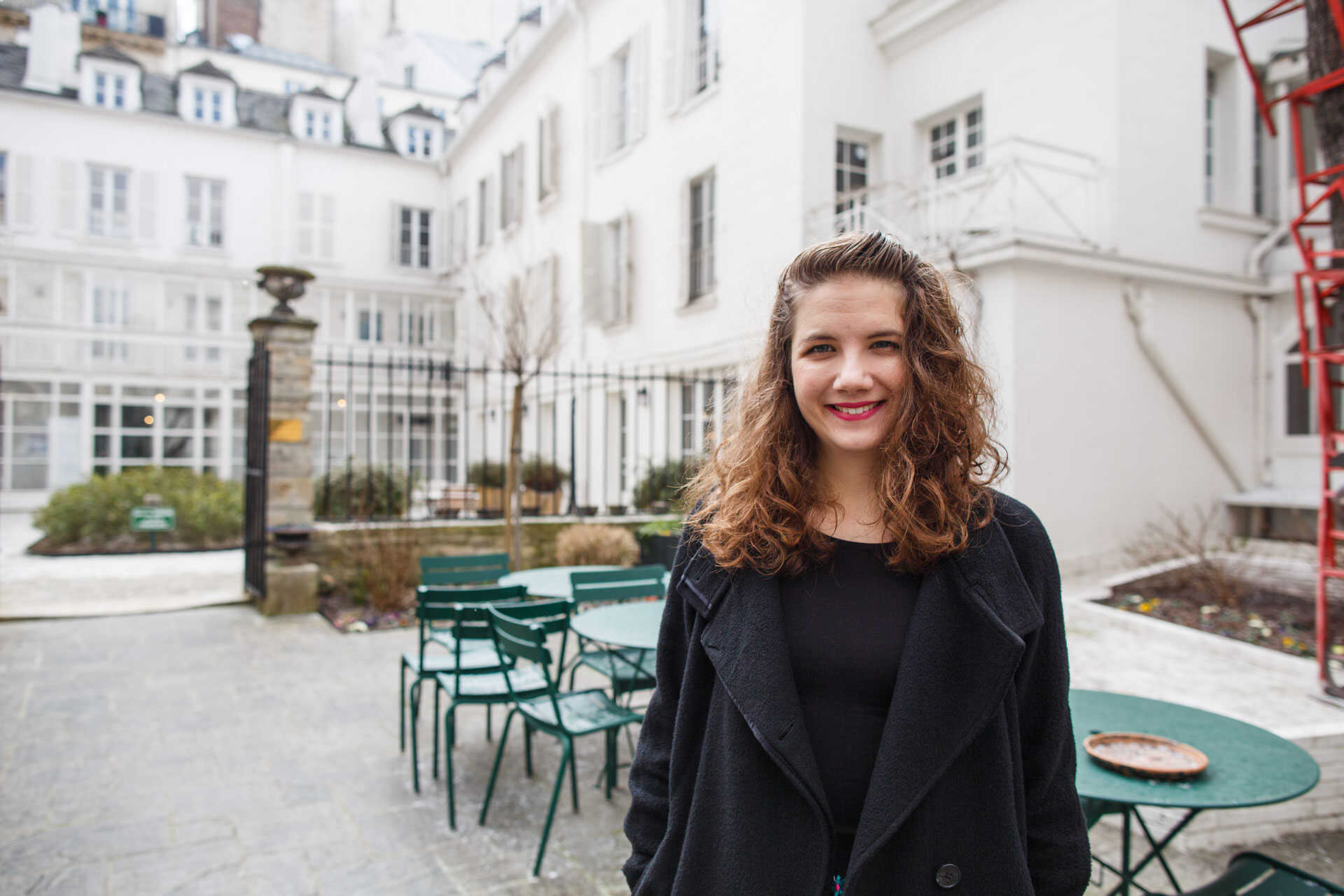 Alice Helliwell, long brown hair, black coat and top, smiling to camera