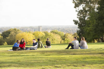 Students sitting on lawn with cathedral in background