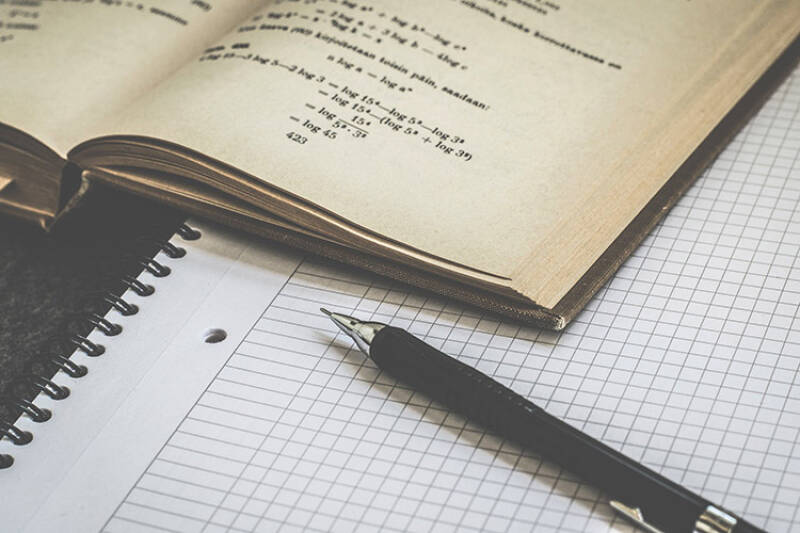Notebook, pen and open mathematics textbook