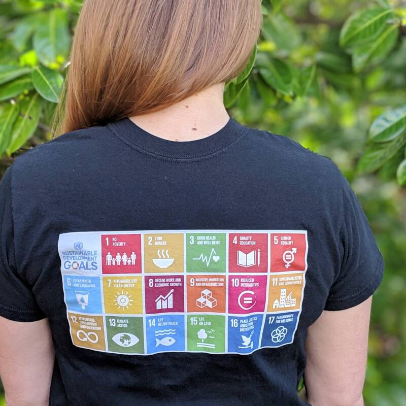 The sustainable development goals printed on the back of a black t shirt
