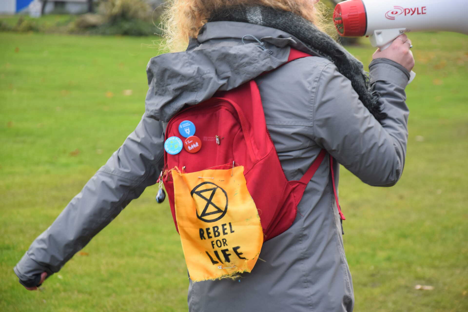 Student with 'rebel for life' on backpack and megaphone in hand