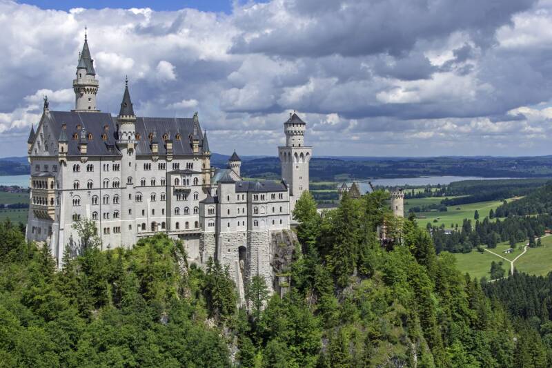 German castle, perched on a hilltop, surrounded by pine forest
