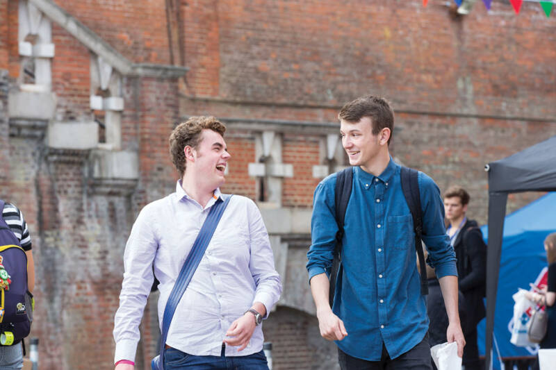 Two male students walking and laughing