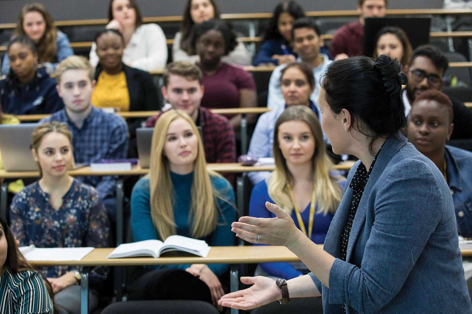 Academic addressing a lecture room full of students