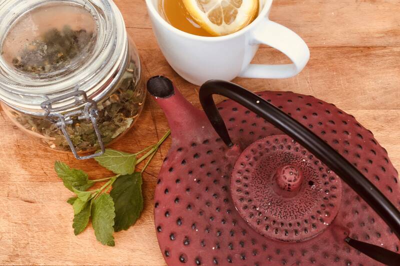 A red teapot and some lemon tea