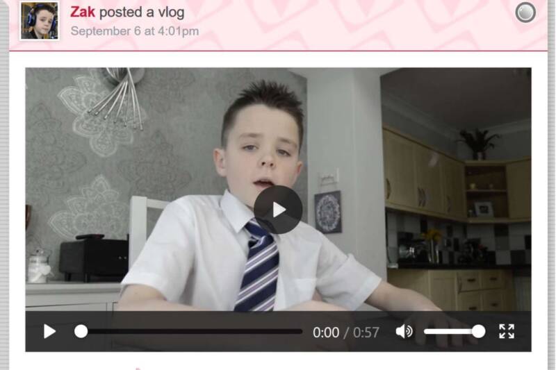 Young boy sitting at home in school uniform posting a vlog