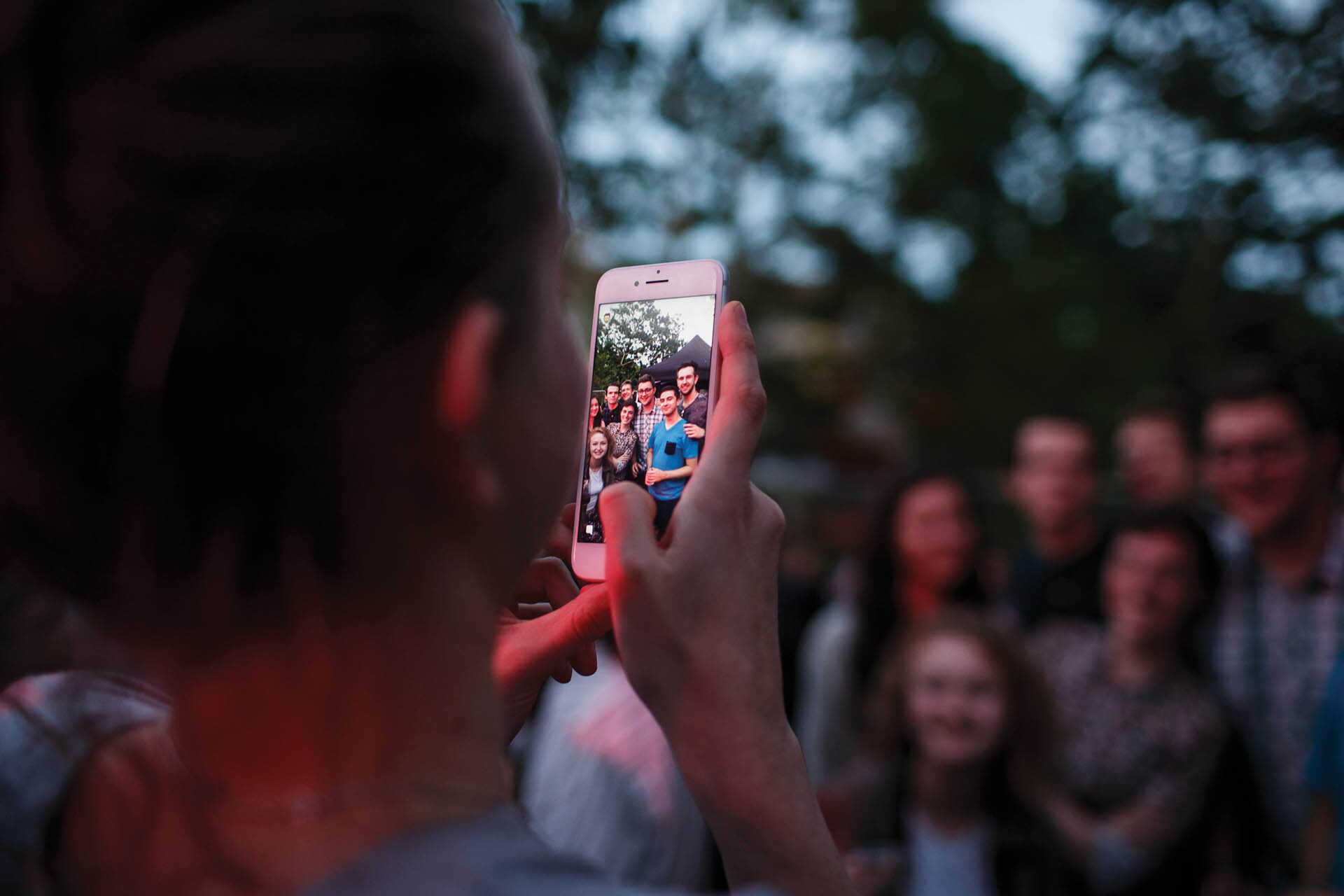 One student taking a photograph of a group of students.