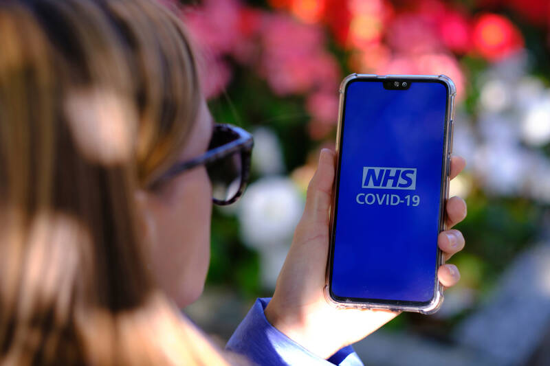 A lady uses the NHS Covid-19 app on her smartphone