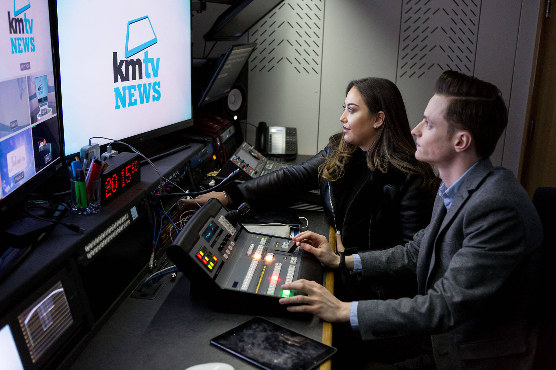 Man and woman at a news desk with KMTV news on the main screen