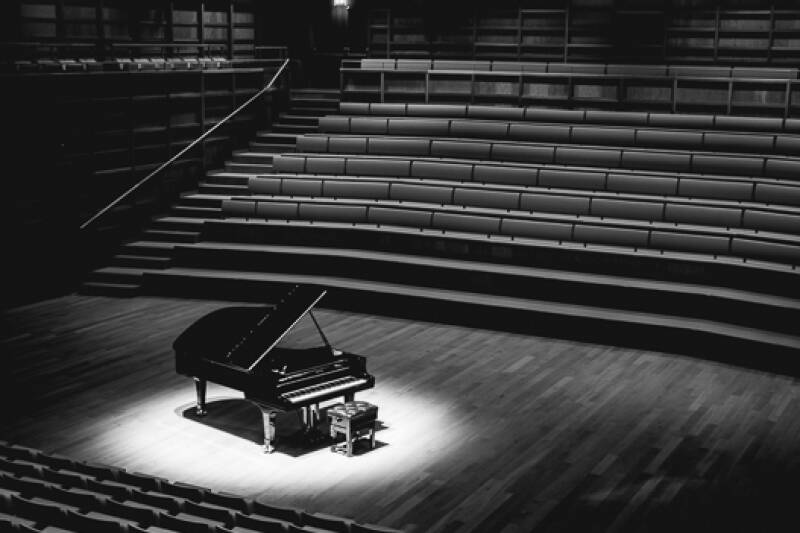 A black-and-white photo shows the Steinway piano spotlight in the concert-hall