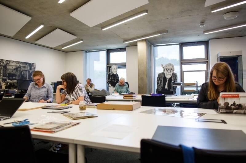 Group of volunteers working at tables in the Special Collections Reading Room.