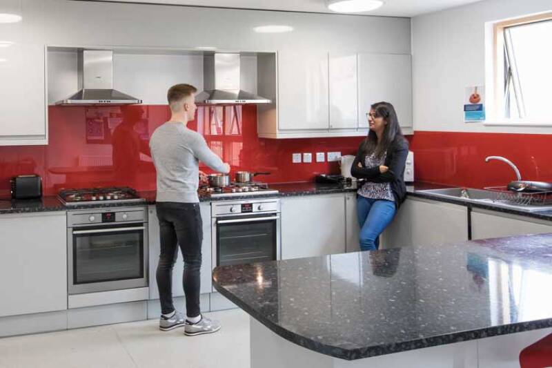 Male and female student talking in the kitchen of Tyler Court B student accommodation