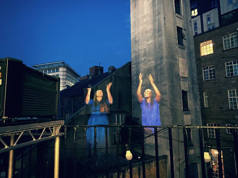 Two women super-imposed over an urban background