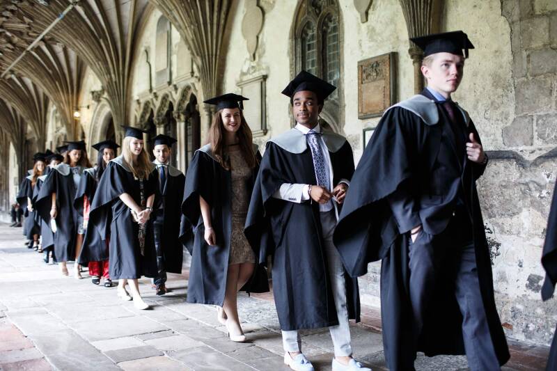 Graduands walking through the cloisters of Canterbury Cathedral