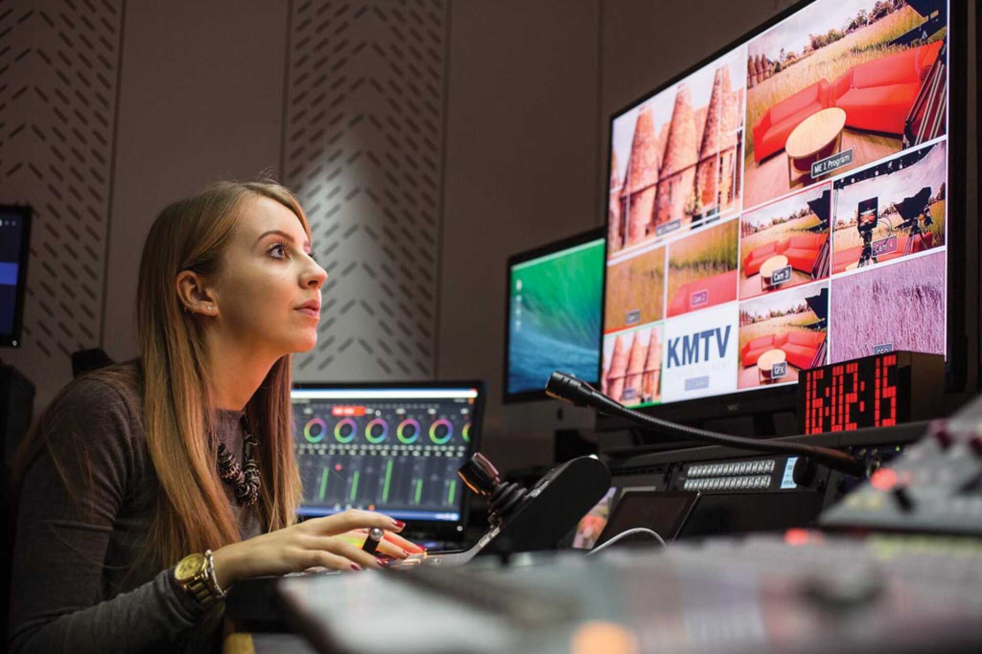 Student in a TV studio, monitoring screens