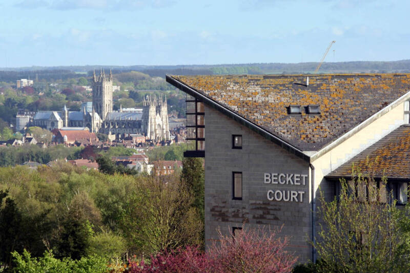 A view of Canterbury Cathedral with Becket Court building in the foreground