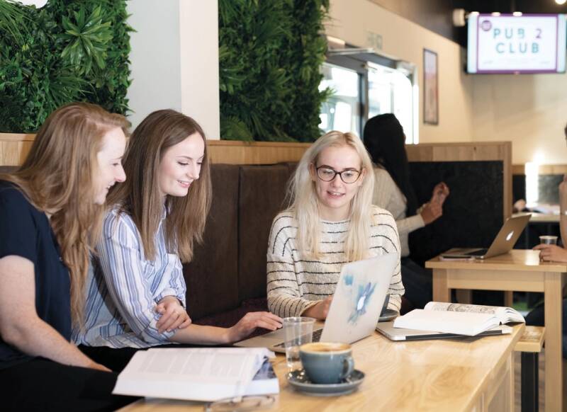 Three individuals sitting in Woody's studying.