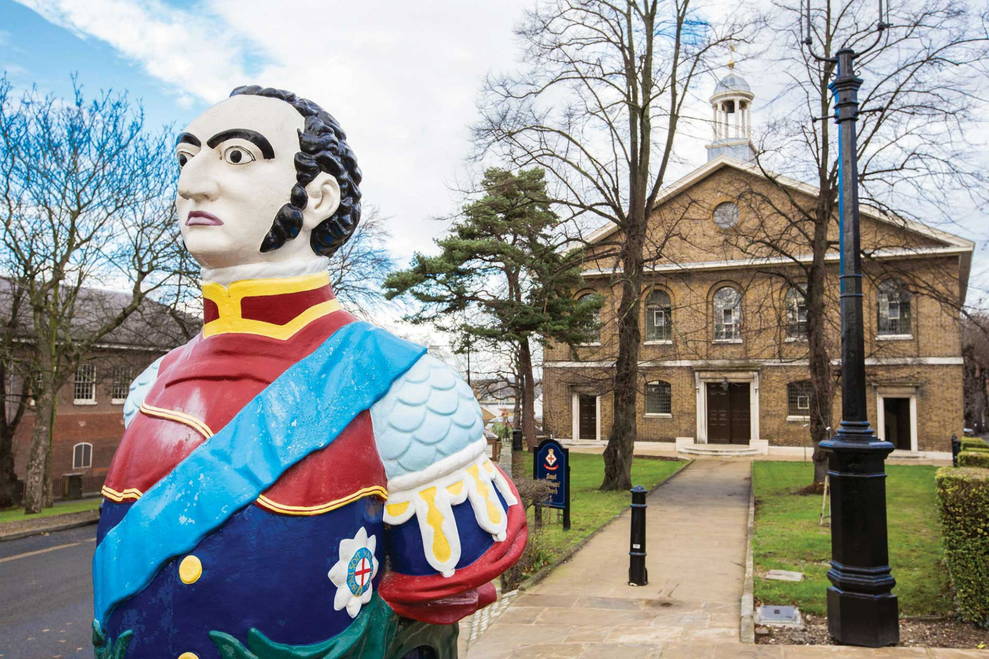 A ship's figurehead of an admiral in front of a period building