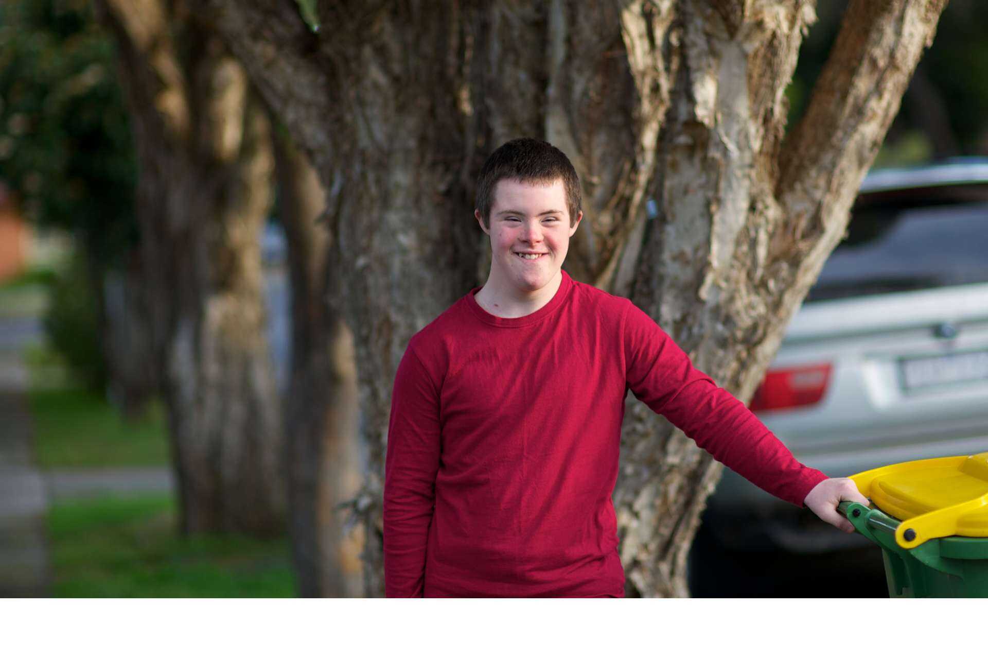 Portrait of a smiling boy in front of a tree