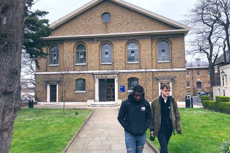 Two students walking away from a building
