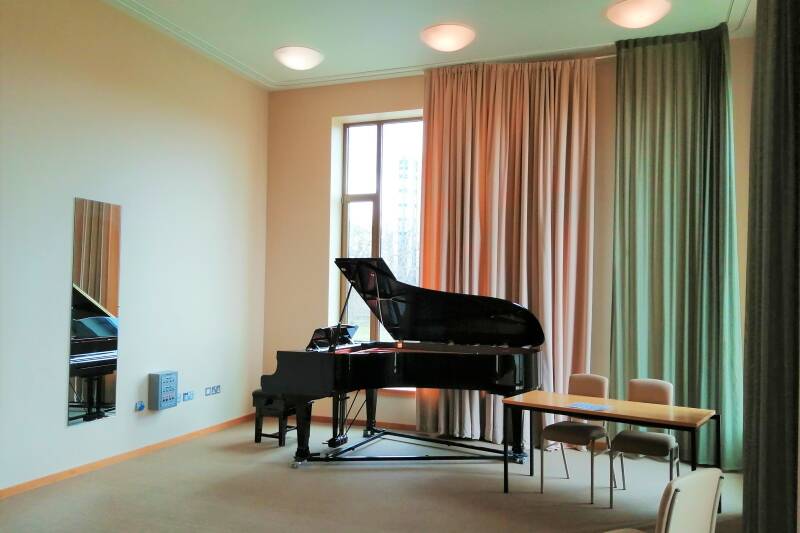 Piano by a window in one of the practice rooms