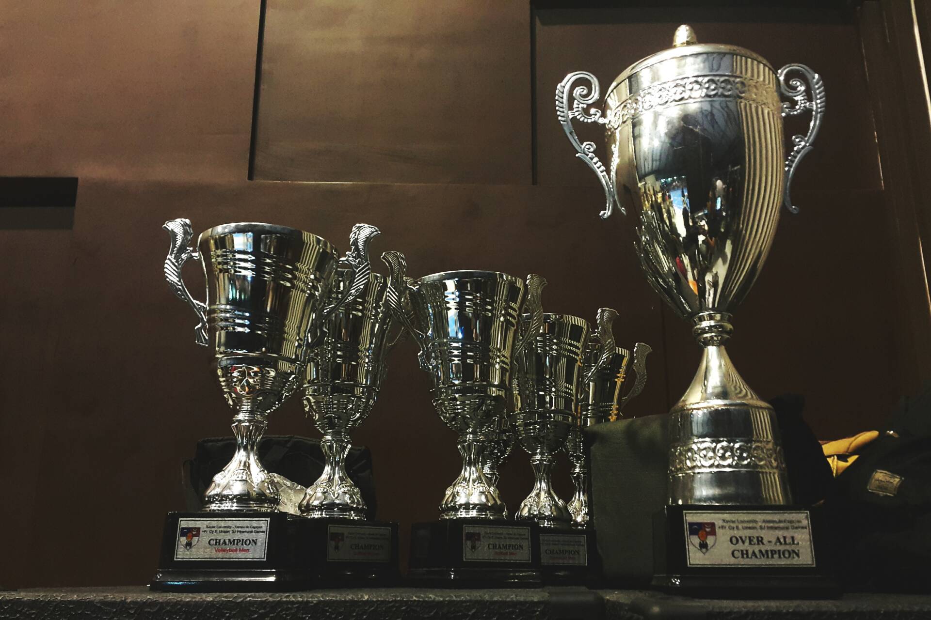 Several trophies against a dark background