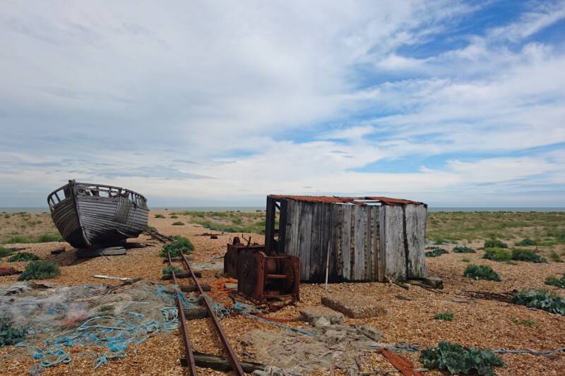 Wrecked boat and shed on pebbled beach of Dungeness