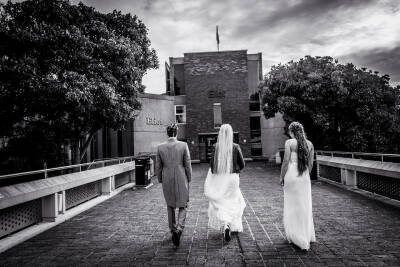 Bride, groom and bridesmaid walking into Eliot College