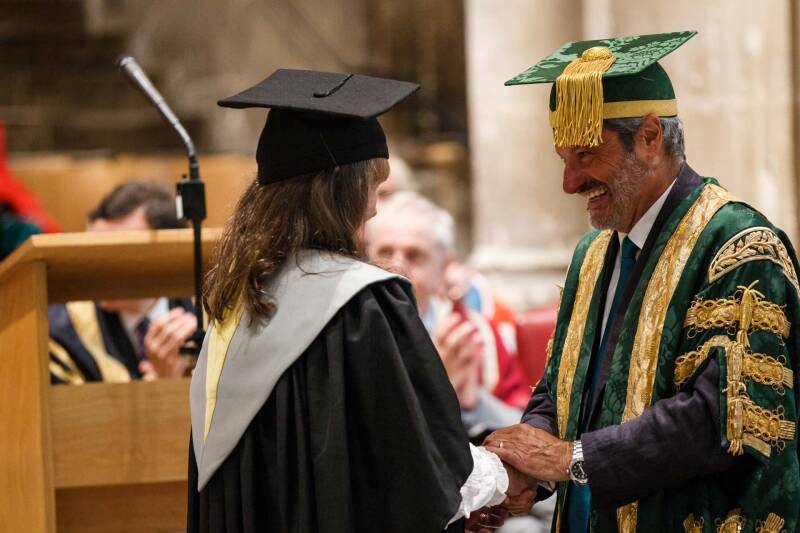A student graduating in Canterbury Cathedral, with Chancellor Gavin Esler
