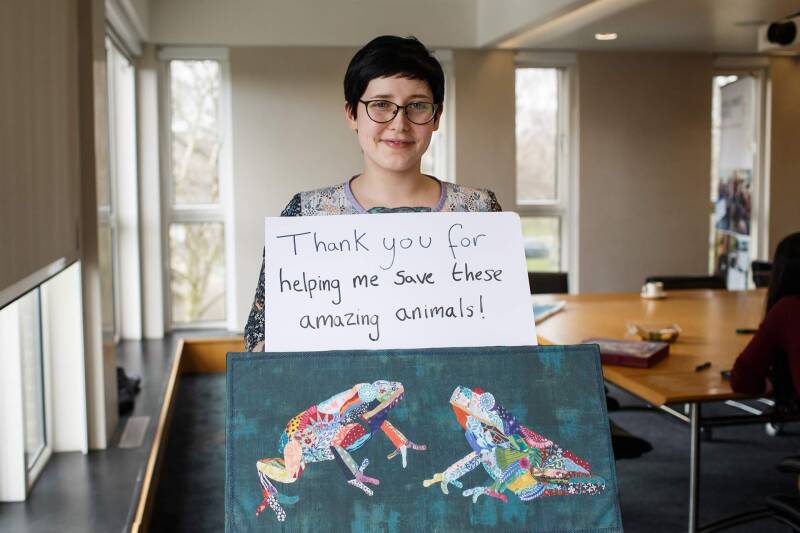 Laura Thomas Walters with a board which reads "Thank you for helping me save these animals"