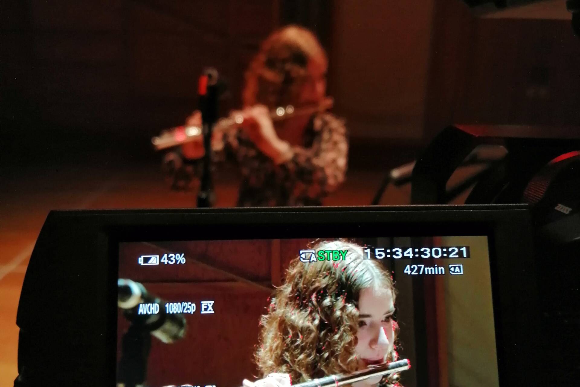 Close up of flute player and video camera