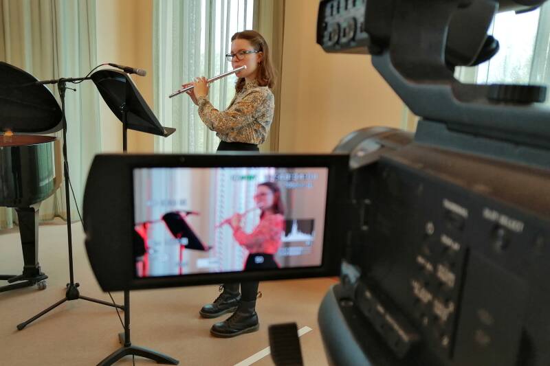 Closeup of female flautist being filmed