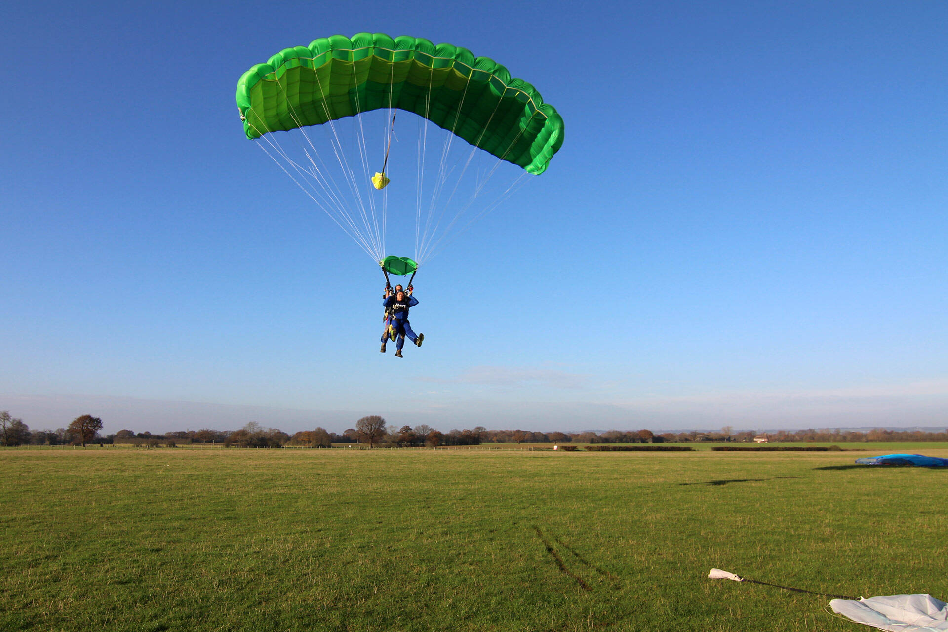 Two people skydiving, coming in to land