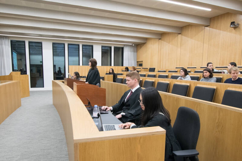 Students wearing gowns shown mooting in our replica courtroom