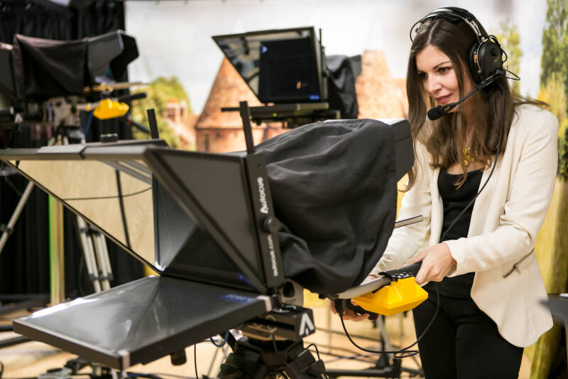 A woman operating a camera in a TV studio