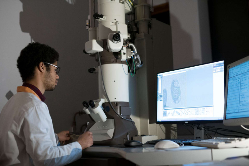 Male student using an electron microscope