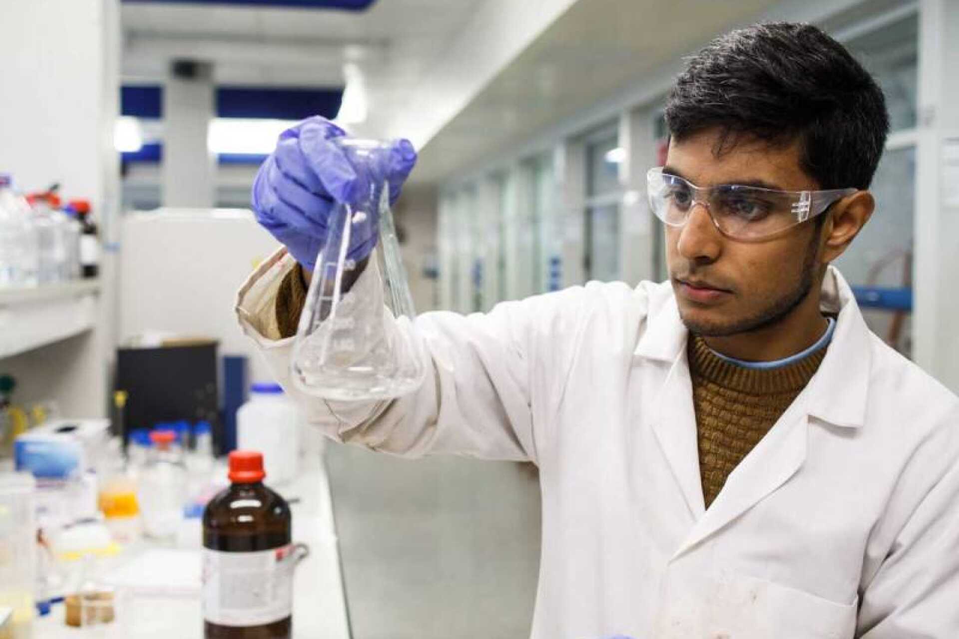 Chemistry student with a conical flask