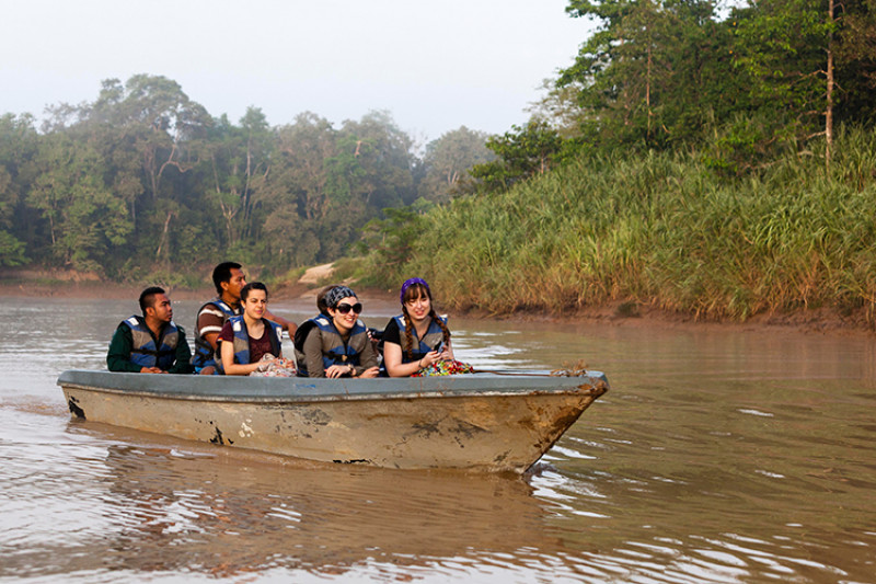 Students in a boat on a river in Borneo