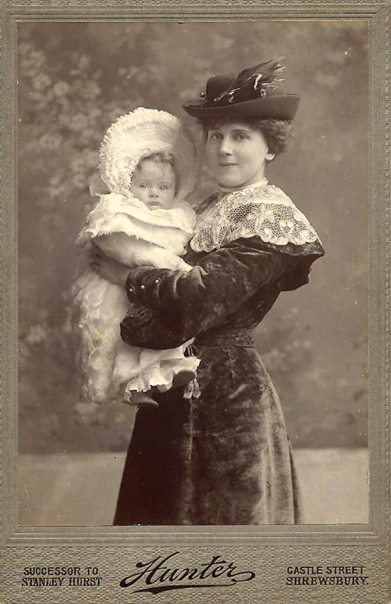 A photograph of Rose Ralph, wife of Andrew Melville II in hat with feather holding Andrew Melville III as a baby.